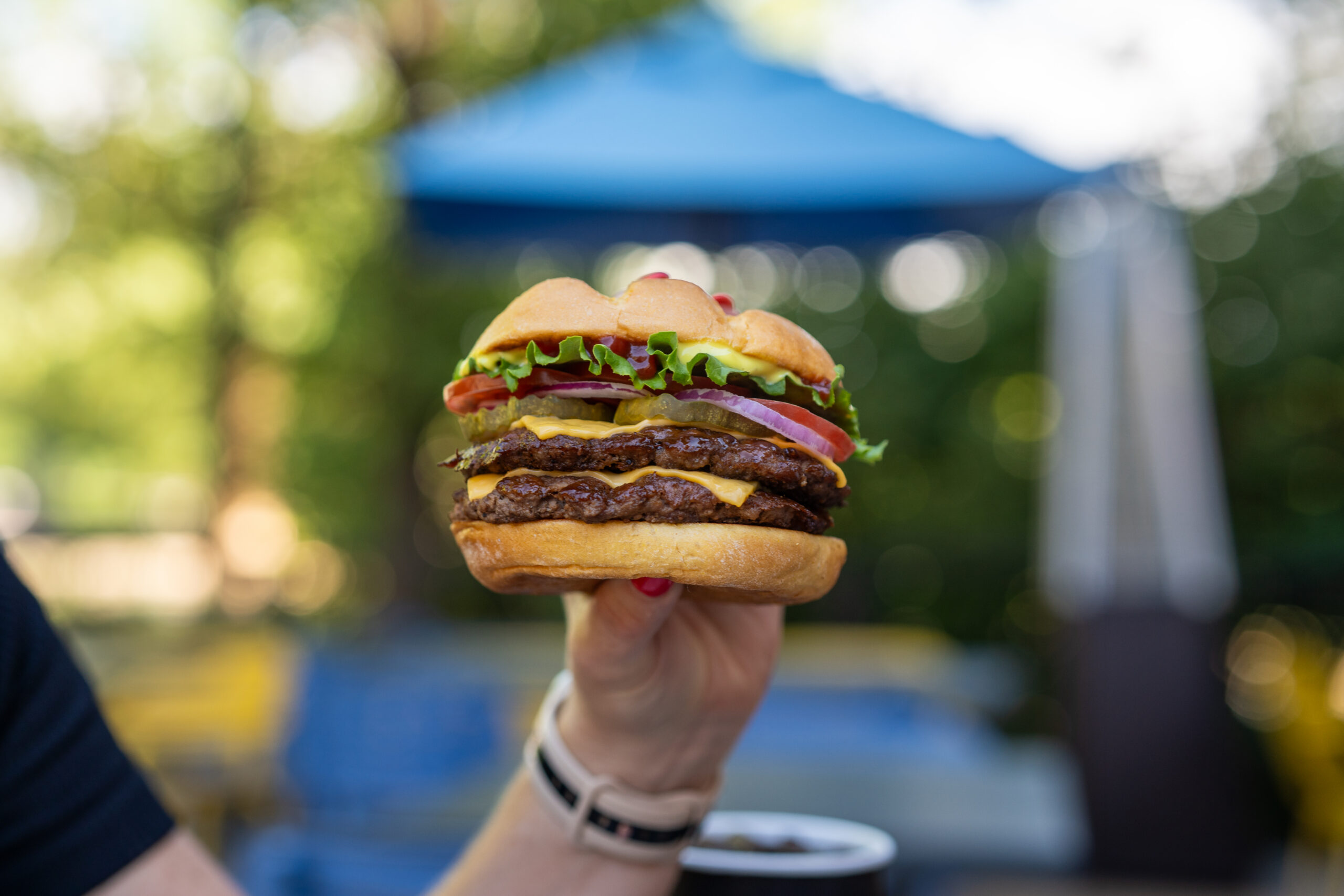 Commercial product photography of a Smashburger held outdoors
