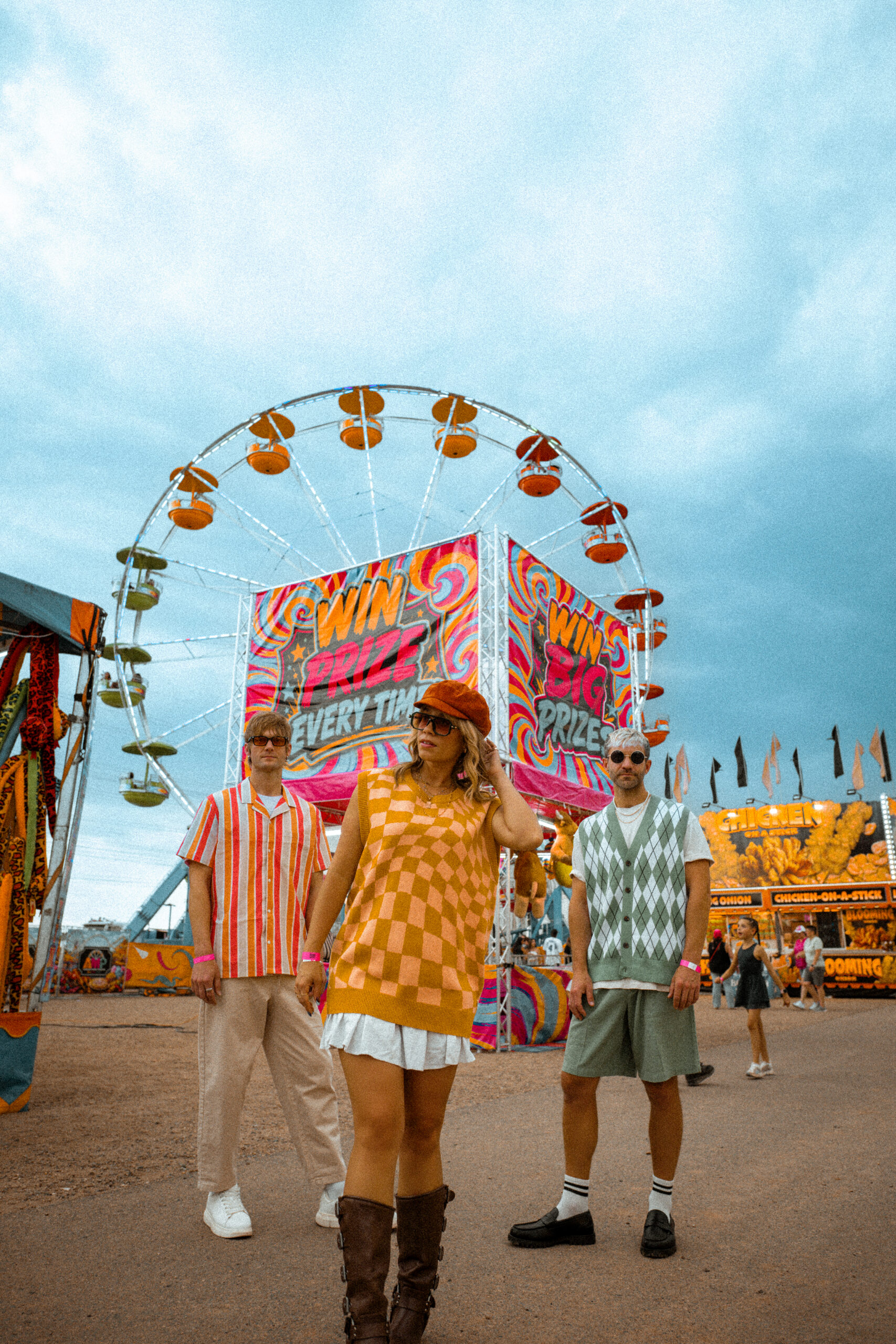 Three cast models in retro wardrobe beneath the Ferris wheel at the Arapahoe County Fair