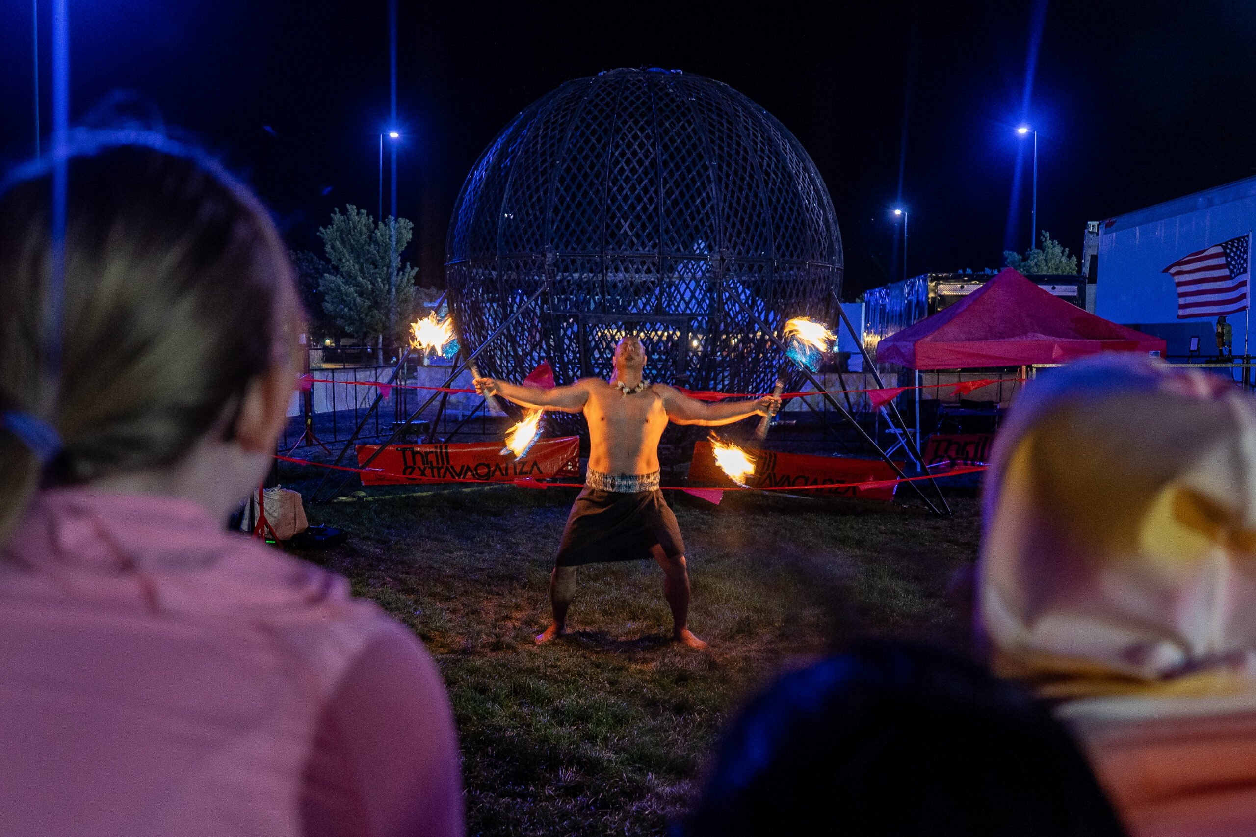 Audience watching a fire performer at night at the Arapahoe County Fair