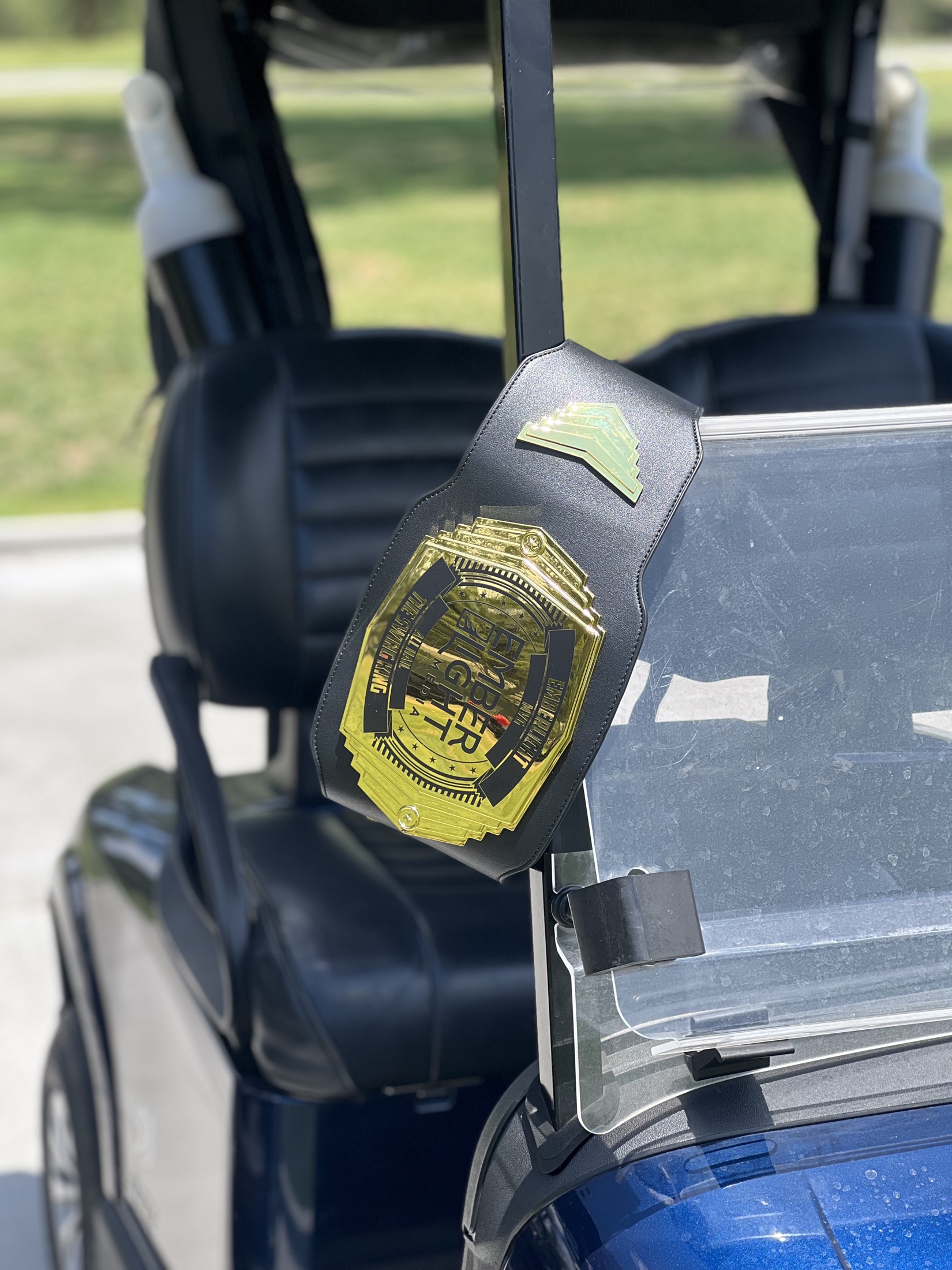 The Emberlight Most Valuable Golfer championship belt on a golf cart
