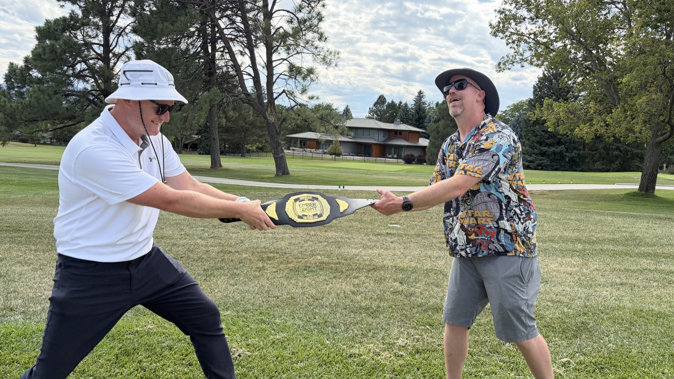 Devin and Charlie playfully competing for the Emberlight Most Valuable Golfer belt